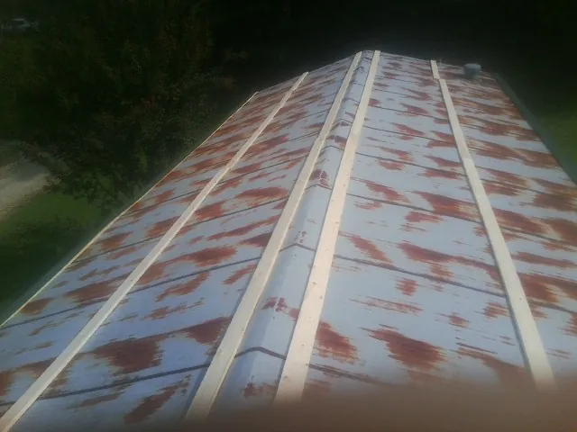 Rusted metal roof panels with new wood purlins before replacement — Storm Damage Roof Repair in Cedar Lane by Roofing Brothers