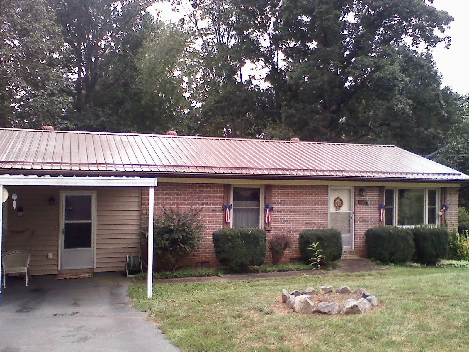 Bronze metal roof and carport on a brick ranch home — Roof Repair work by our crew in Cedar Lane